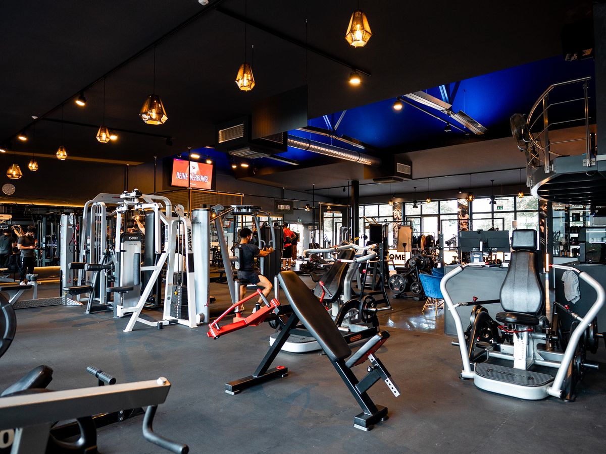Moderne Trainingsfläche im GymOne 24/7 Bitburg heute mit neuen Geräten und stilvoller Beleuchtung